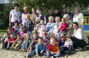 Kinder der Kita mit Erzieherinnen von heute und damals.